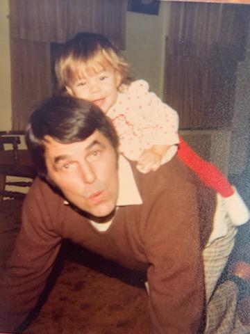 A vintage family photograph: Ann's dad gives young Ann a piggyback ride in their living room